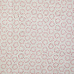 Detail of fabric in a playful circular print in pink on a greige field.