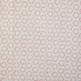 Detail of fabric in a playful circular print in pink on a greige field.