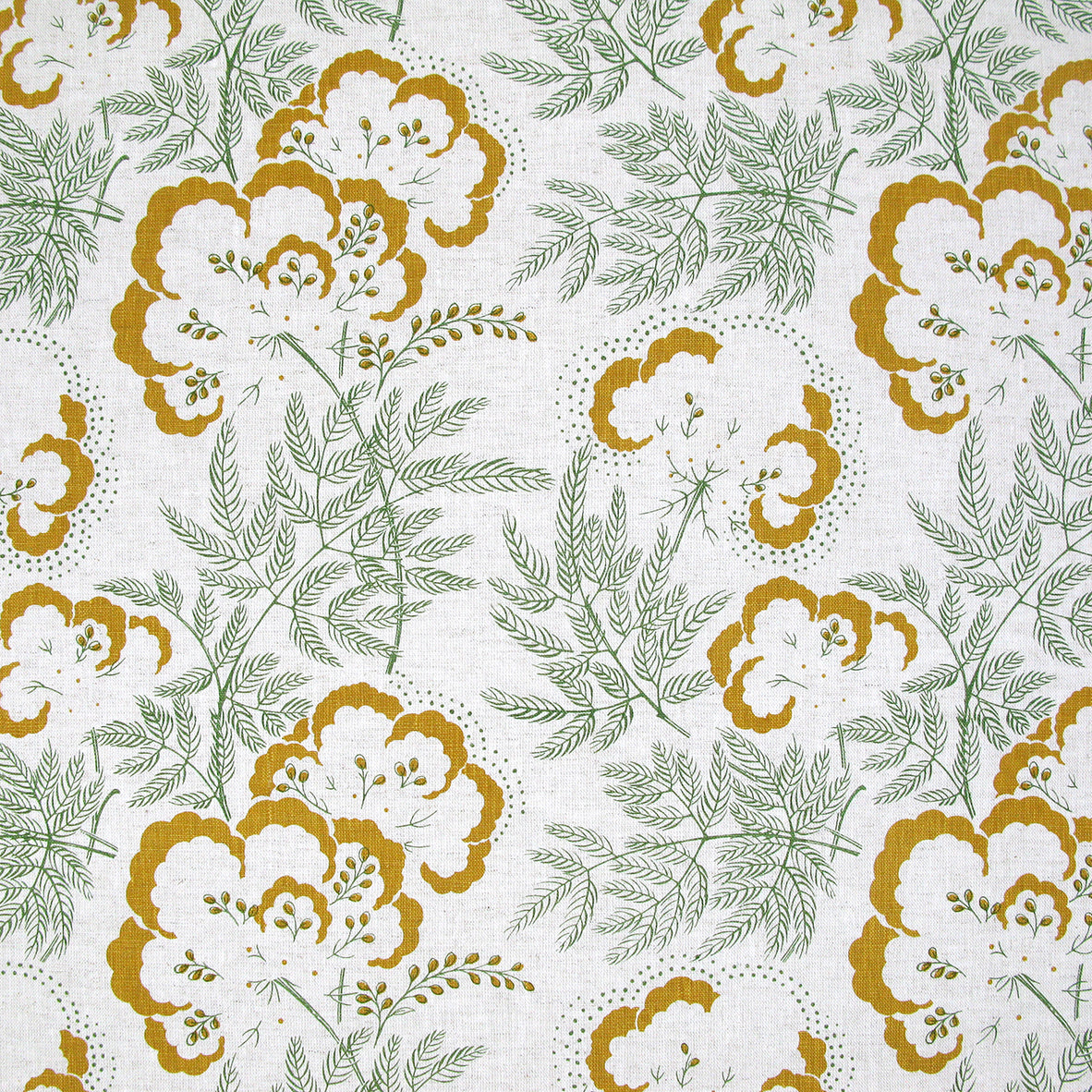 Detail of fabric in an intricate floral print in mustard and green on a white field.