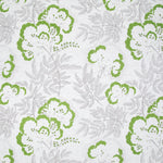 Detail of fabric in an intricate floral print in green and gray on a white field.