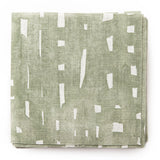 A stack of fabric swatches in a painterly small-scale grid print in sage on a white field.