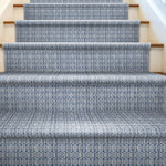 Staircase with patterned blue and white runner on wooden steps.