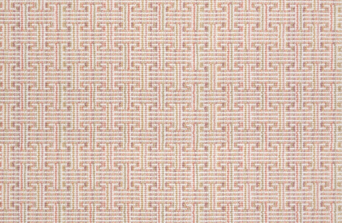 Patterned carpet with a geometric design in pastel pink and white