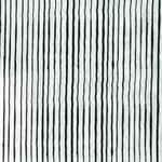 Fabric in a painterly stripe pattern in black on a white field.