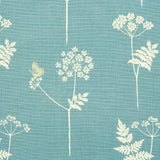 Detail of fabric in a playful flower and butterfly print in cream and tan on a blue field.