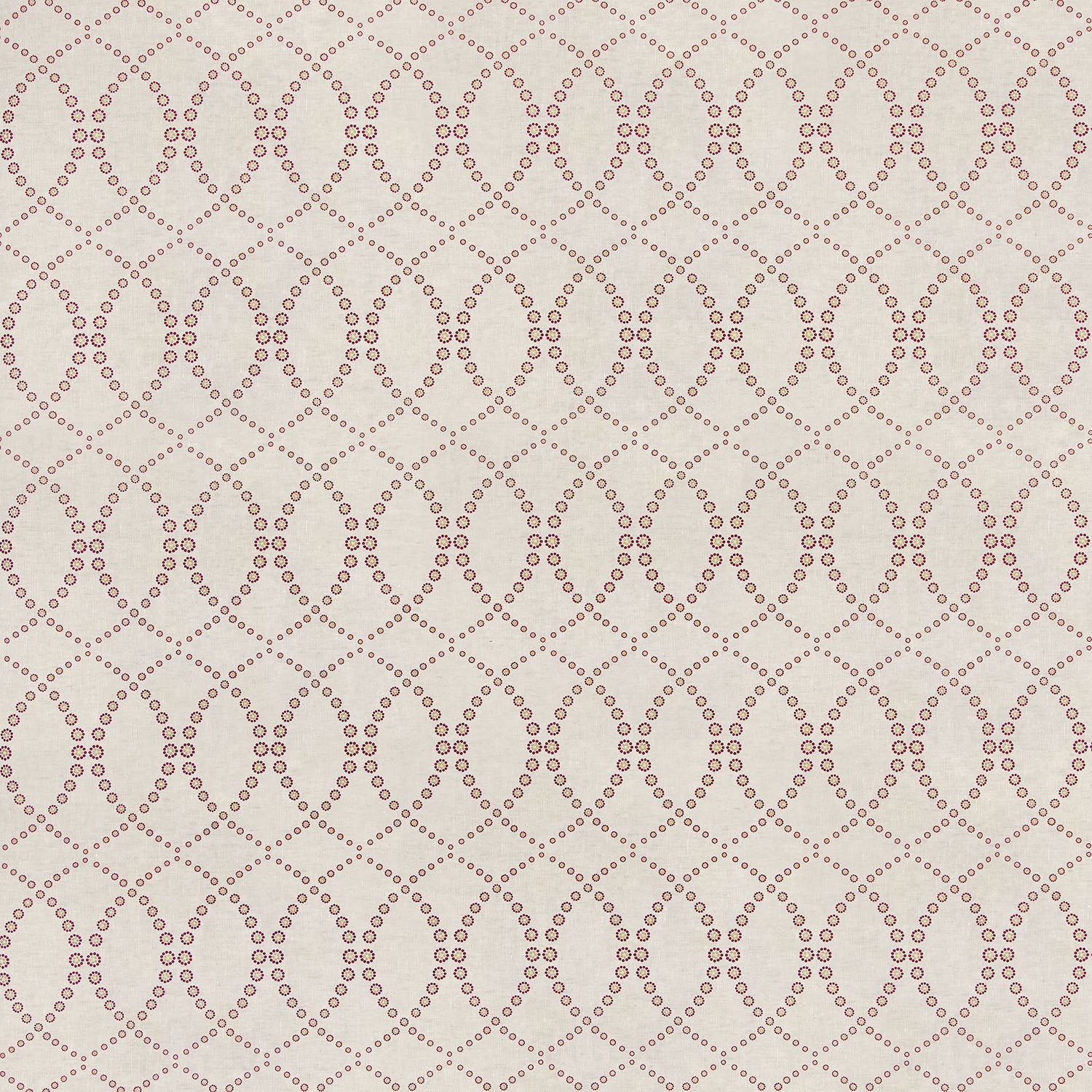 Detail of fabric in a playful floral lattice print in orange and maroon on a tan field.