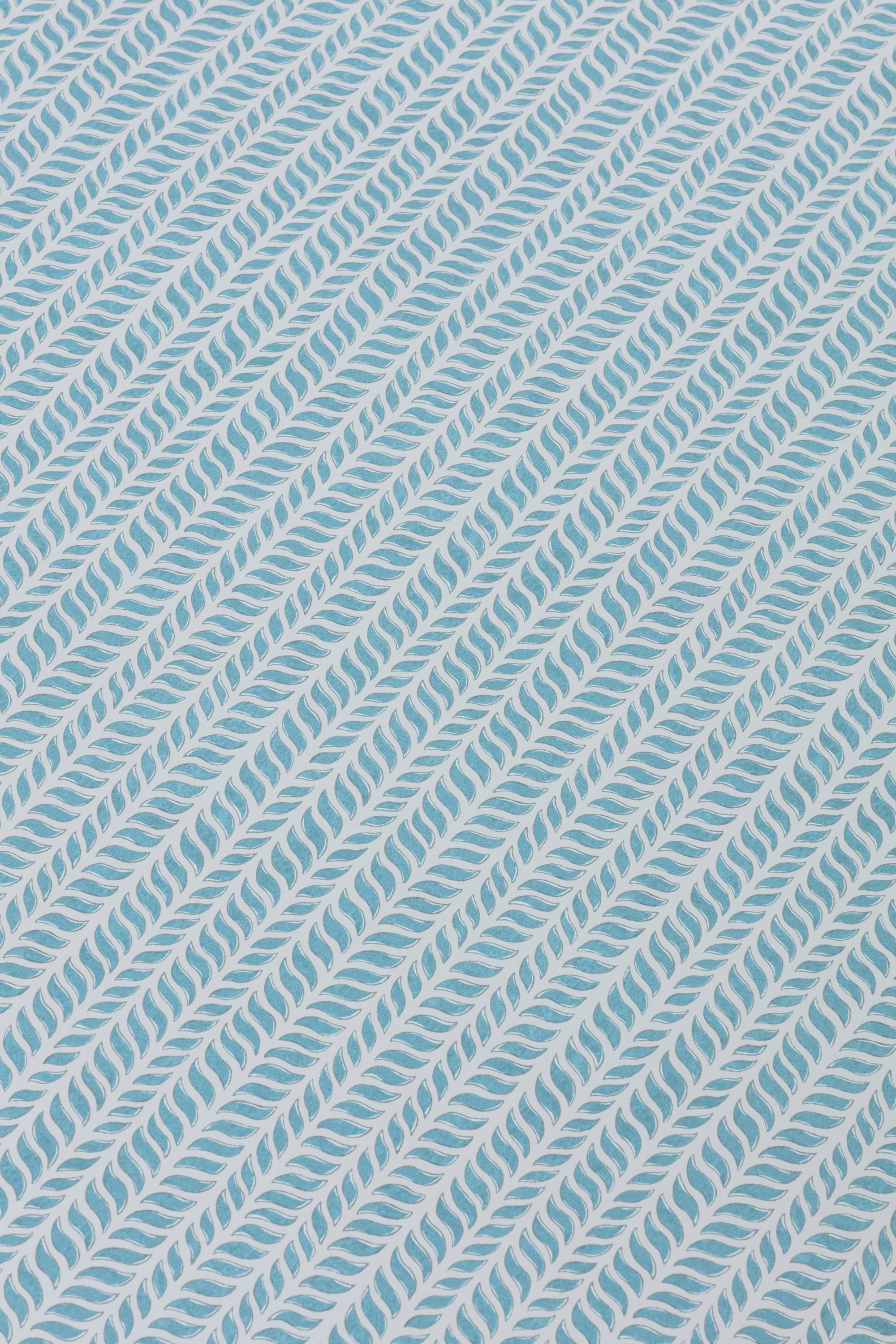 Detail of a wallpaper panel in a painterly herringbone print in sky blue on a light blue field.