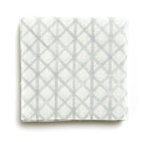 A stack of fabric swatches in an intricate striped grid pattern in light blue on a white field.