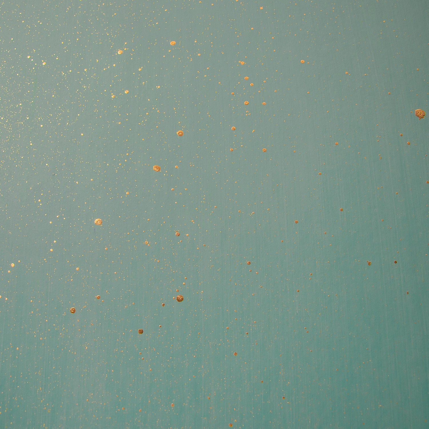 Detail of a wallpaper in a random splattered pattern in metallic gold on a green field.