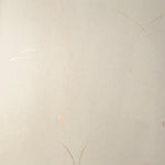 Detail of a wallpaper in an elongated paint splatter pattern in metallic gold on a cream field.