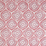 Detail of fabric in a floral lattice print in pink and red on a cream field.