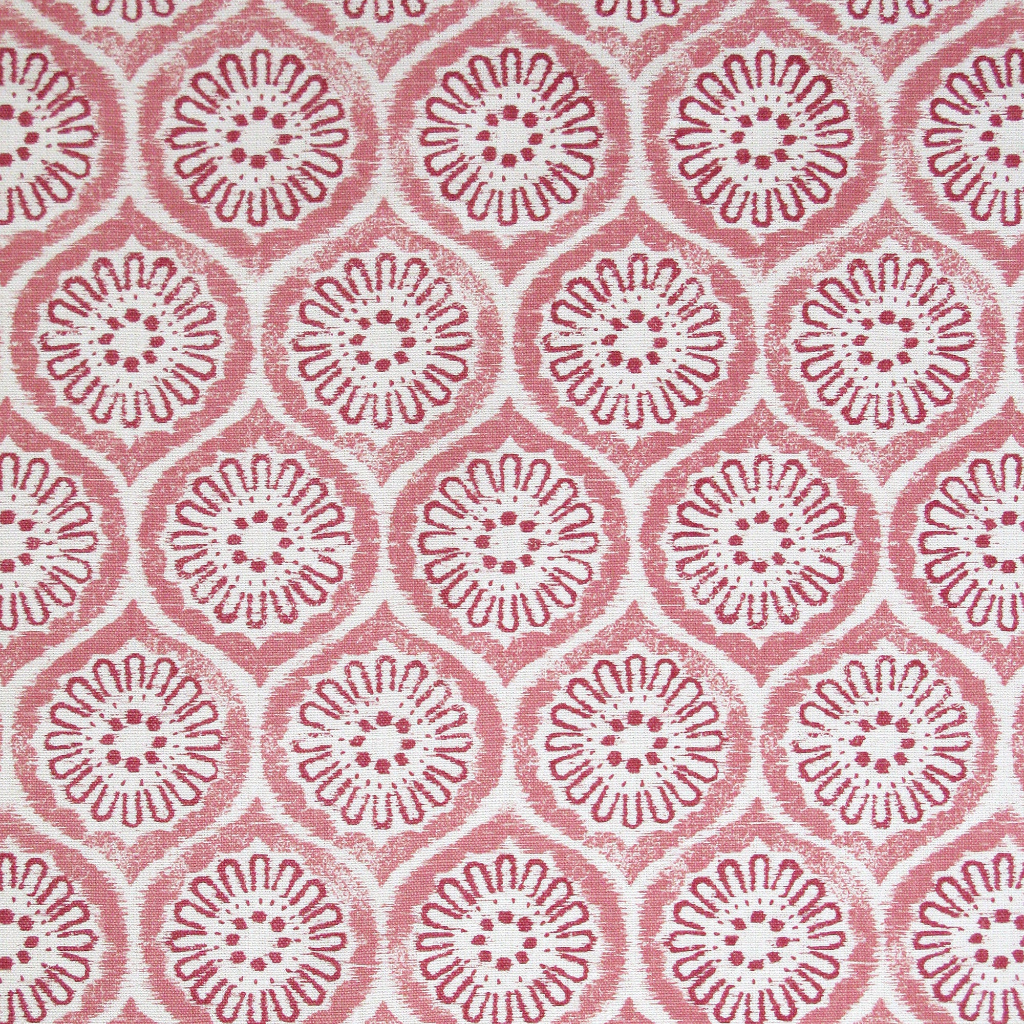 Detail of fabric in a floral lattice print in pink and red on a cream field.