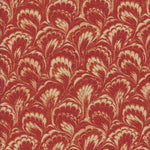 Detail of fabric in a marbled paint print in shades of red, orange and tan.