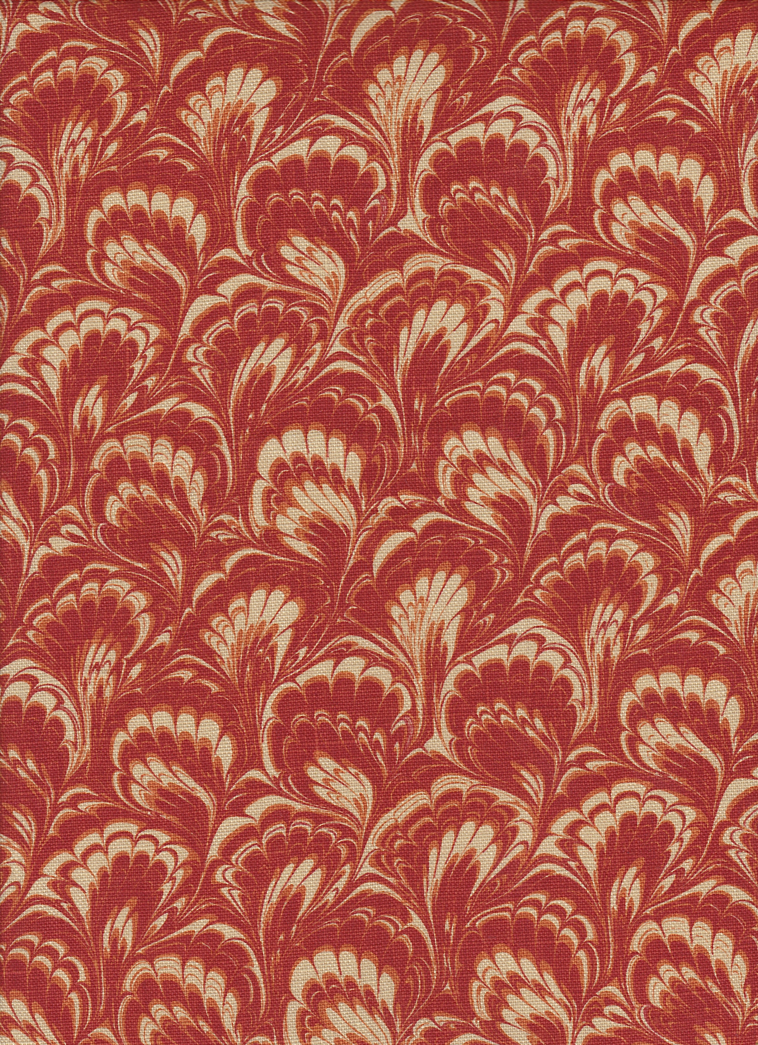 Detail of fabric in a marbled paint print in shades of red, orange and tan.