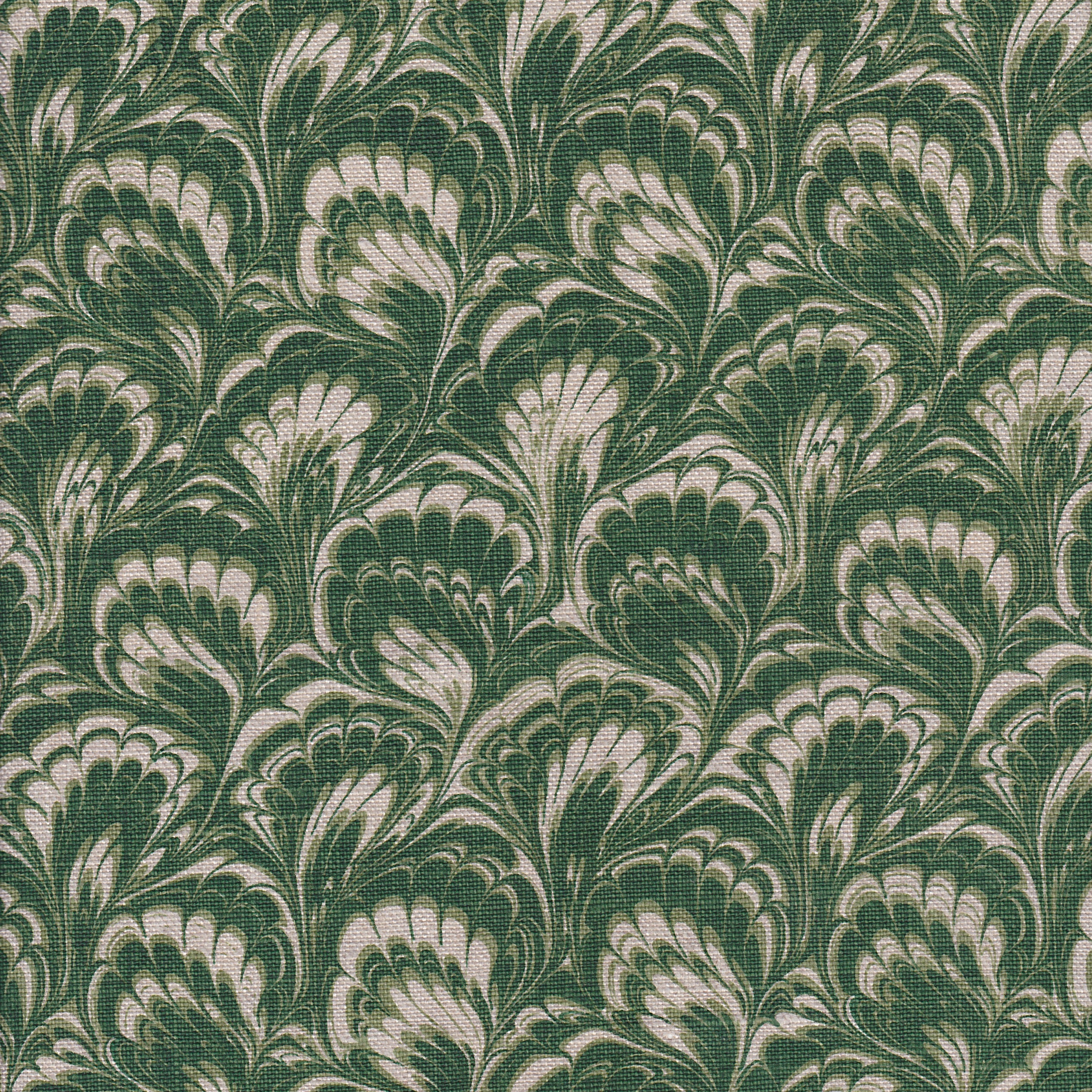 Detail of fabric in a marbled paint print in shades of green and cream.