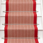 Striped flatweave runner in orange and red on white staircase