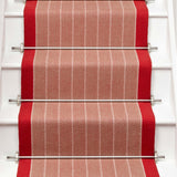 Striped flatweave runner in orange and red on white staircase