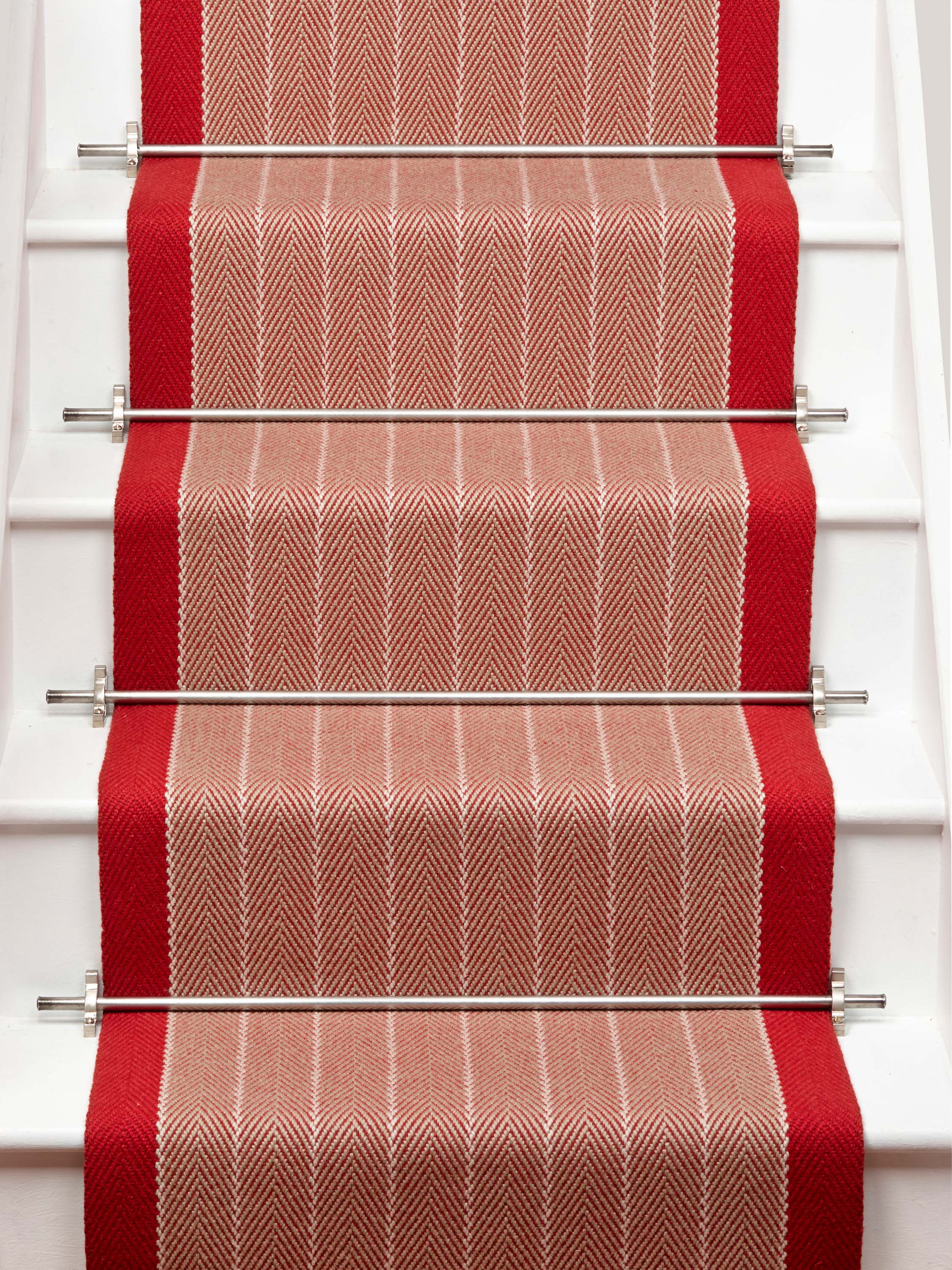 Striped flatweave runner in orange and red on white staircase