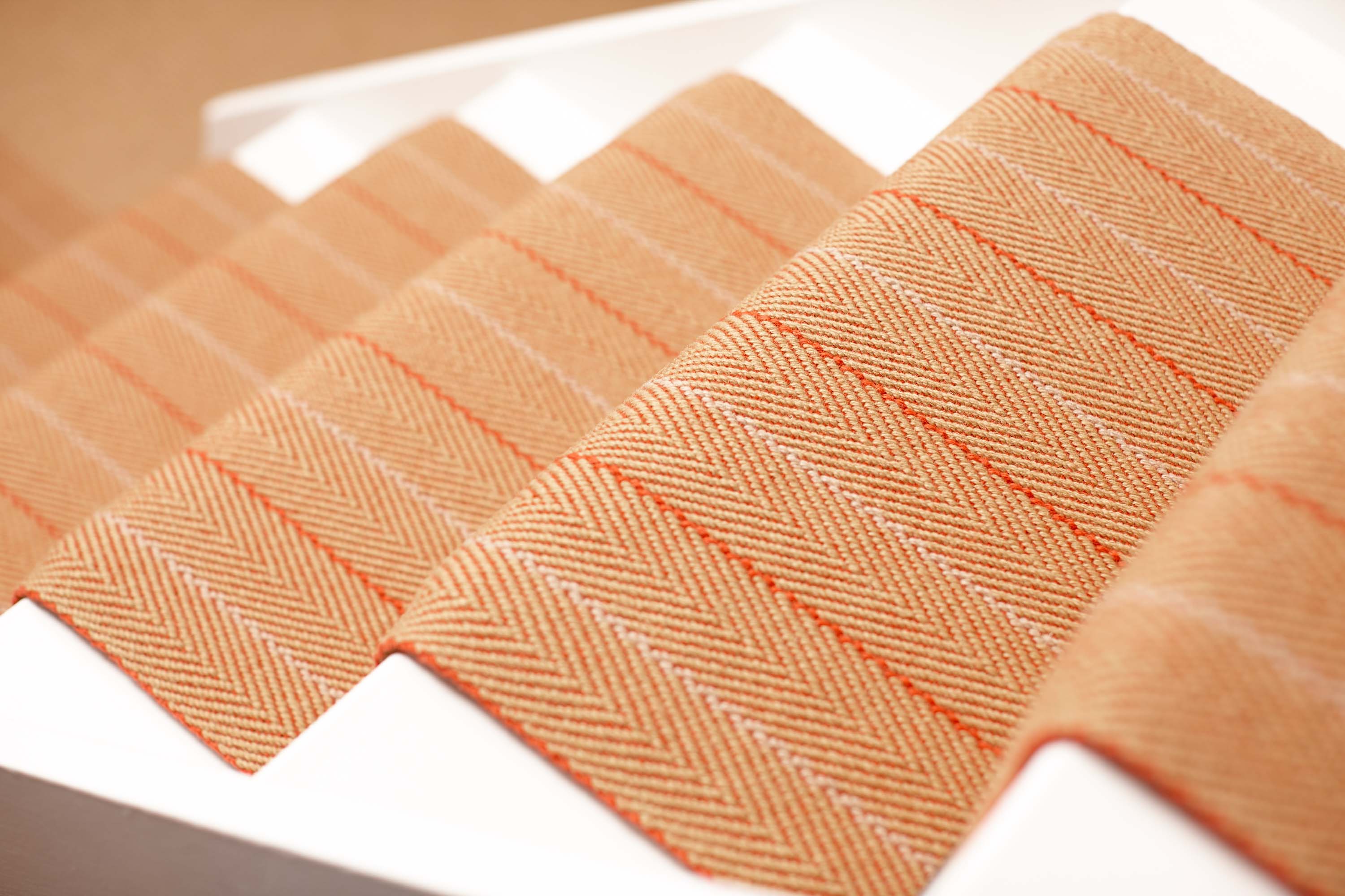 Striped flatweave runner in orange on white staircase