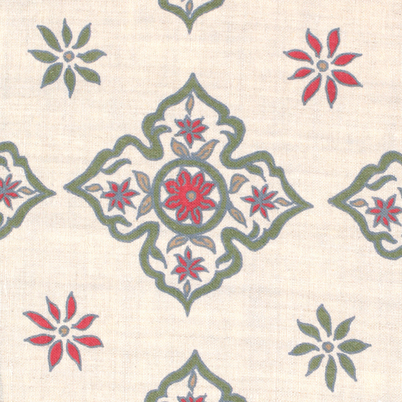 Detail of fabric in a diamond damask print in shades of green, red and blue on a tan field.