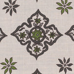 Detail of fabric in a diamond damask print in shades of green and gray on a cream field.