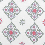 Detail of fabric in a diamond damask print in shades of green, red and blue on a cream field.