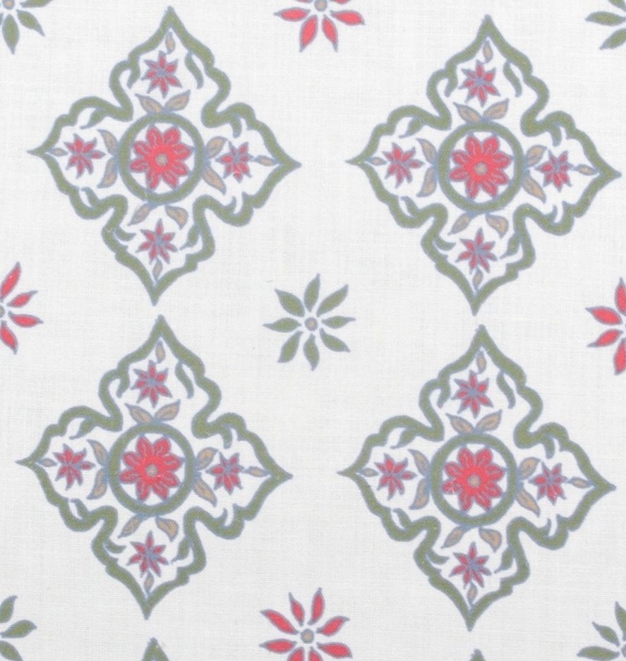 Detail of fabric in a diamond damask print in shades of green, red and blue on a cream field.