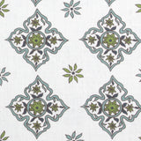 Detail of fabric in a diamond damask print in shades of green and blue on a white field.