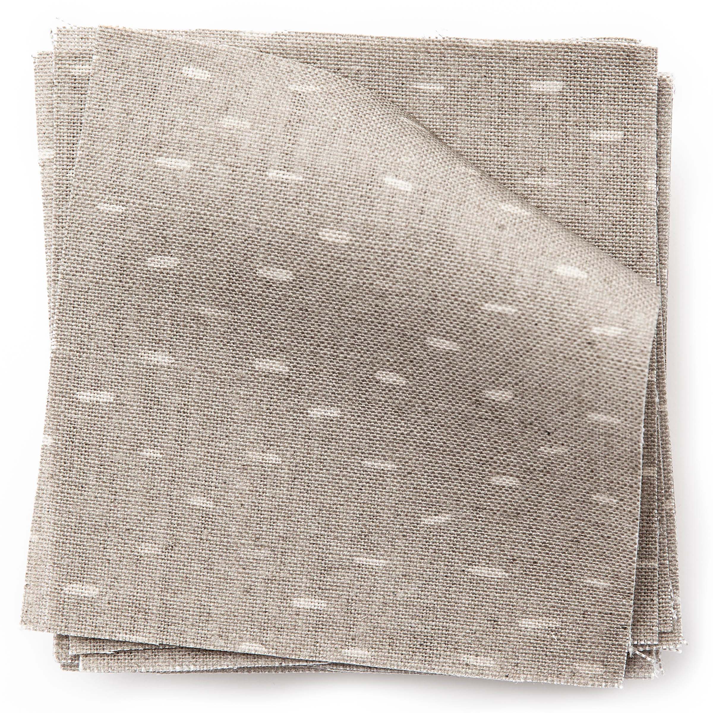A stack of fabric swatches in a dotted diamond grid in cream on a light brown field.