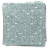 A stack of fabric swatches in a dotted diamond grid in white on a blue field.