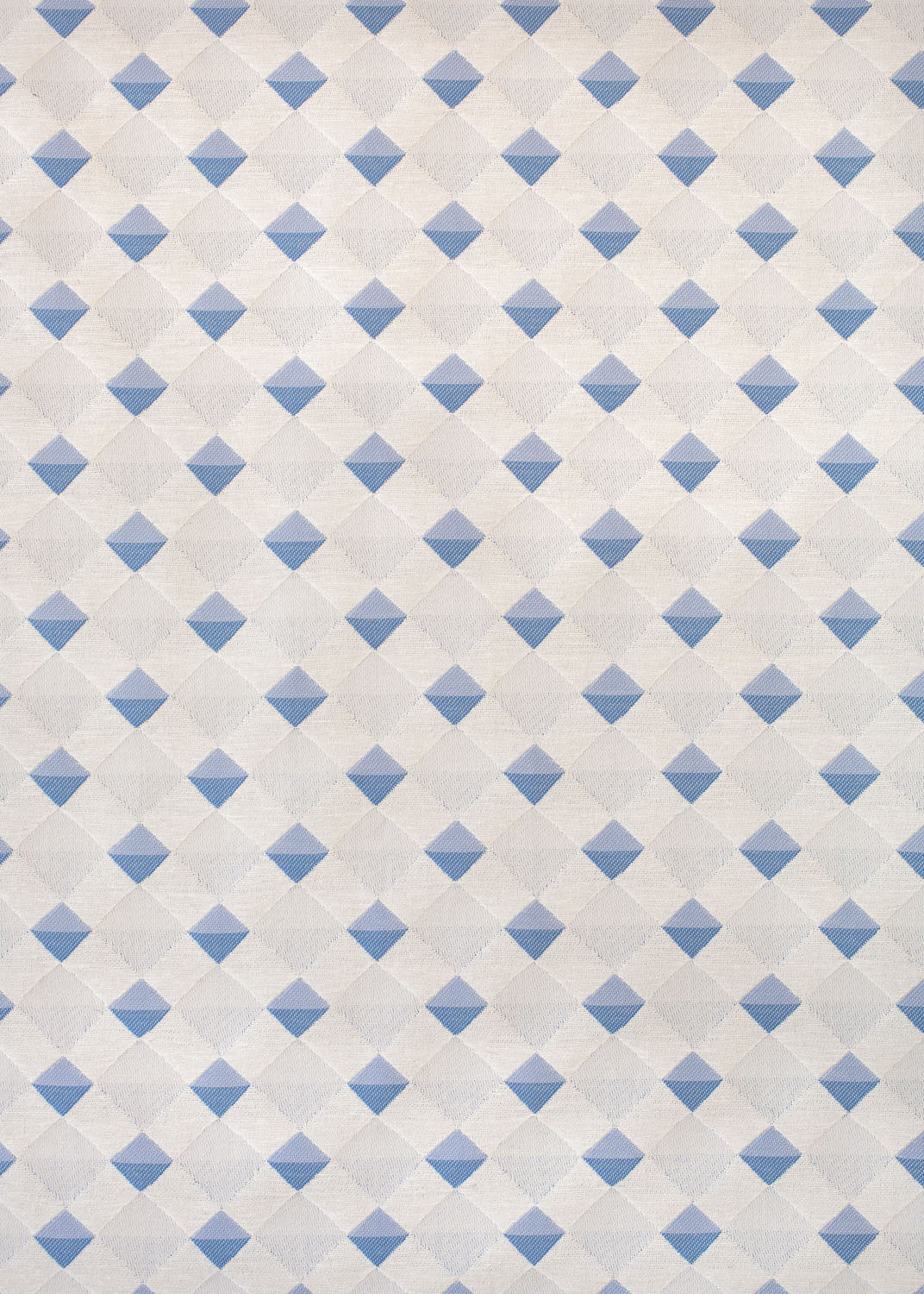 Detail of fabric in a textural diamond lattice print in blue on a cream field.