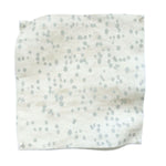 Square fabric swatch in an abstract dotted pattern in light blue on a mottled cream field.
