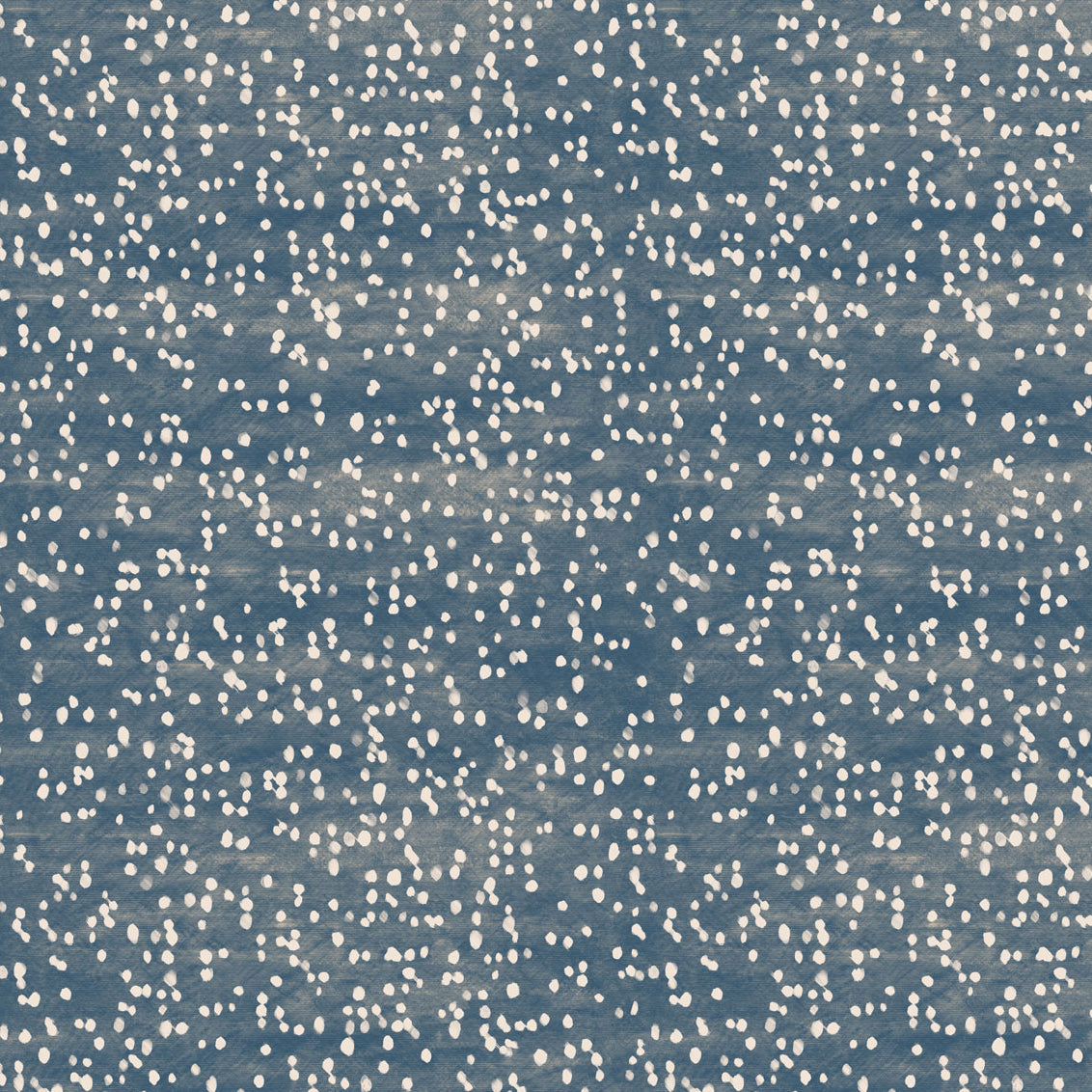 Detail of fabric in an abstract dotted pattern in white on a mottled denim field.