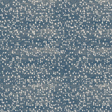 Detail of fabric in an abstract dotted pattern in white on a mottled denim field.