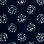 Detail of a printed cotton fabric in a repeating dotted pattern in white on an indigo field.