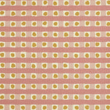 Detail of fabric in a playful dotted check print in pink and mustard on a cream field.