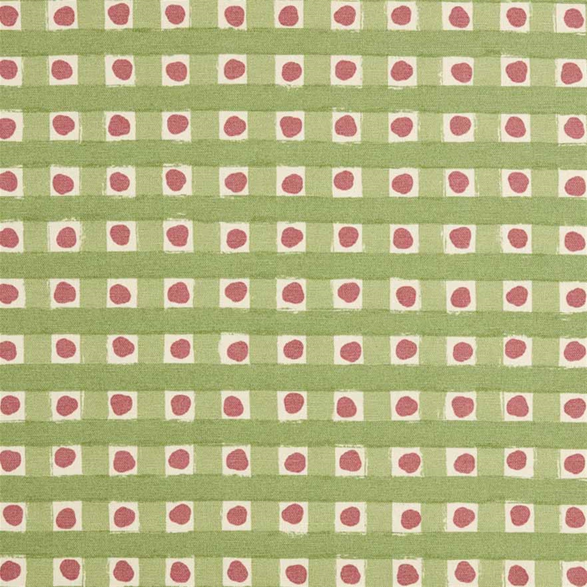 Detail of fabric in a playful dotted check print in pink and green on a cream field.