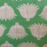 Detail of fabric in a repeating lotus print in tan and white on a green field.