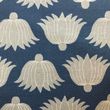 Detail of fabric in a repeating lotus print in yellow and white on a navy field.