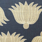 Detail of fabric in a repeating lotus print in yellow and white on a navy field.