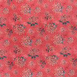 printed linen fabric in a repeating floral pattern in shades of yellow and green on a red field.