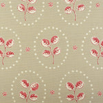 Detail of fabric in a repeating leaf print in red and cream on a light brown field.