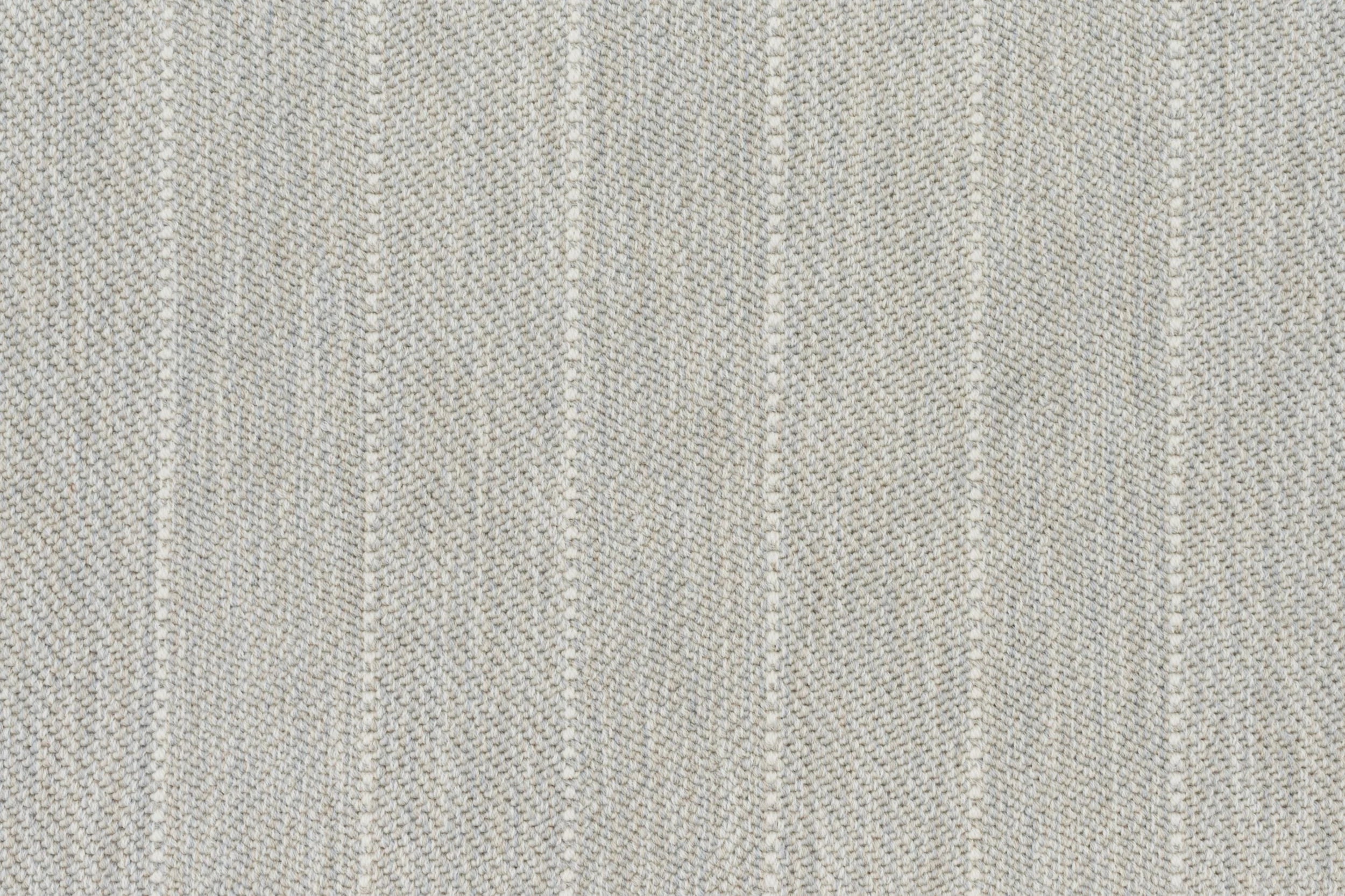 Broadloom carpet in a herringbone stripe pattern in pale grey.