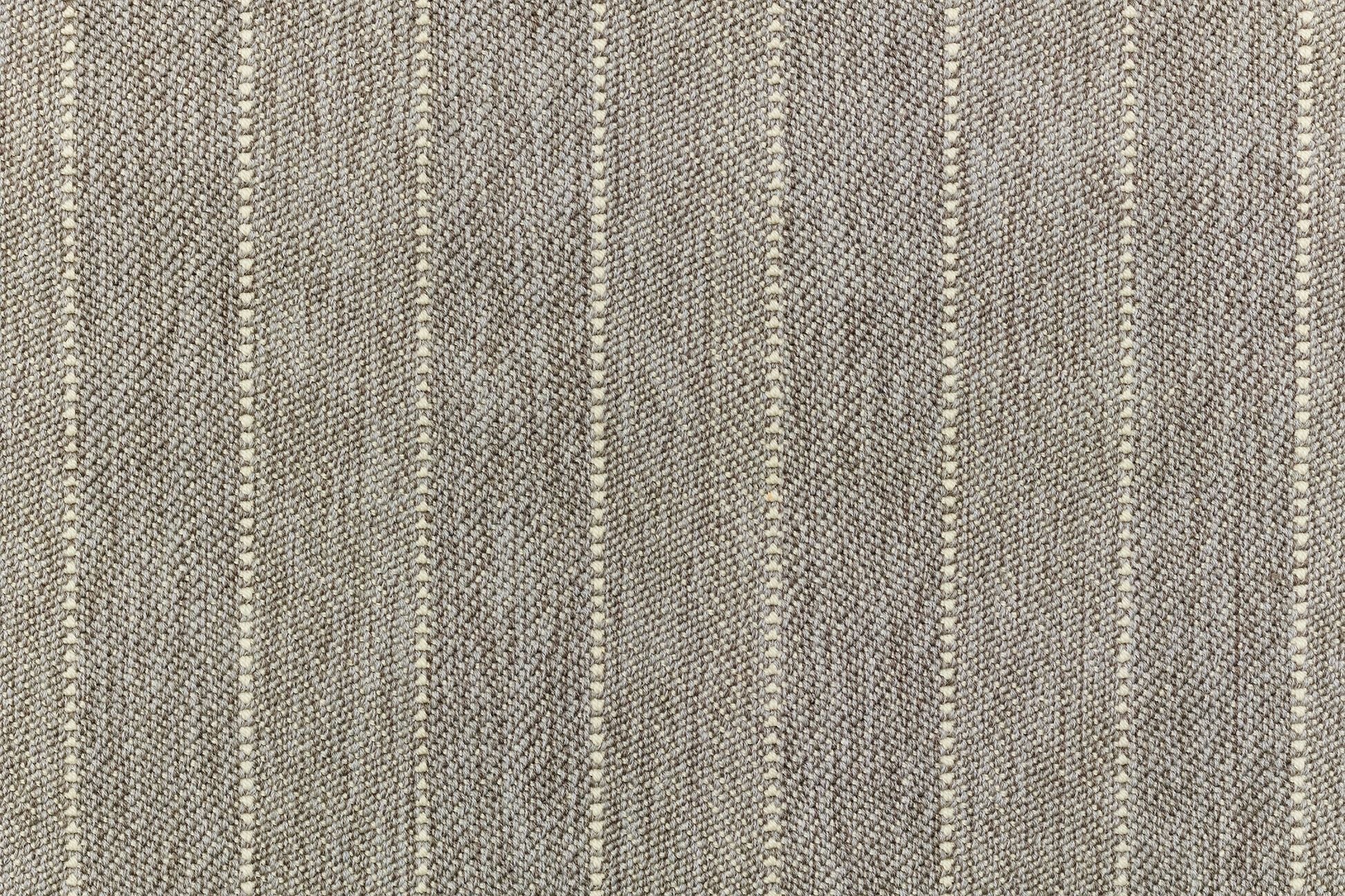 Broadloom carpet in a herringbone stripe pattern in taupe.