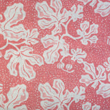 Detail of fabric in a playful botanical print in light pink and white on a pink field.