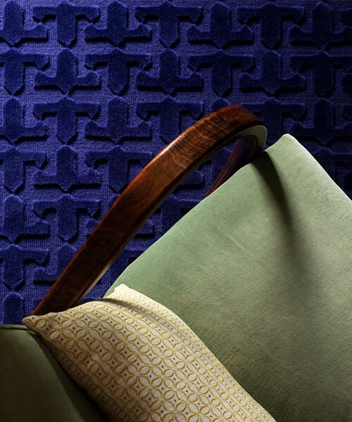 Green upholstered side chair against a textured blue carpet