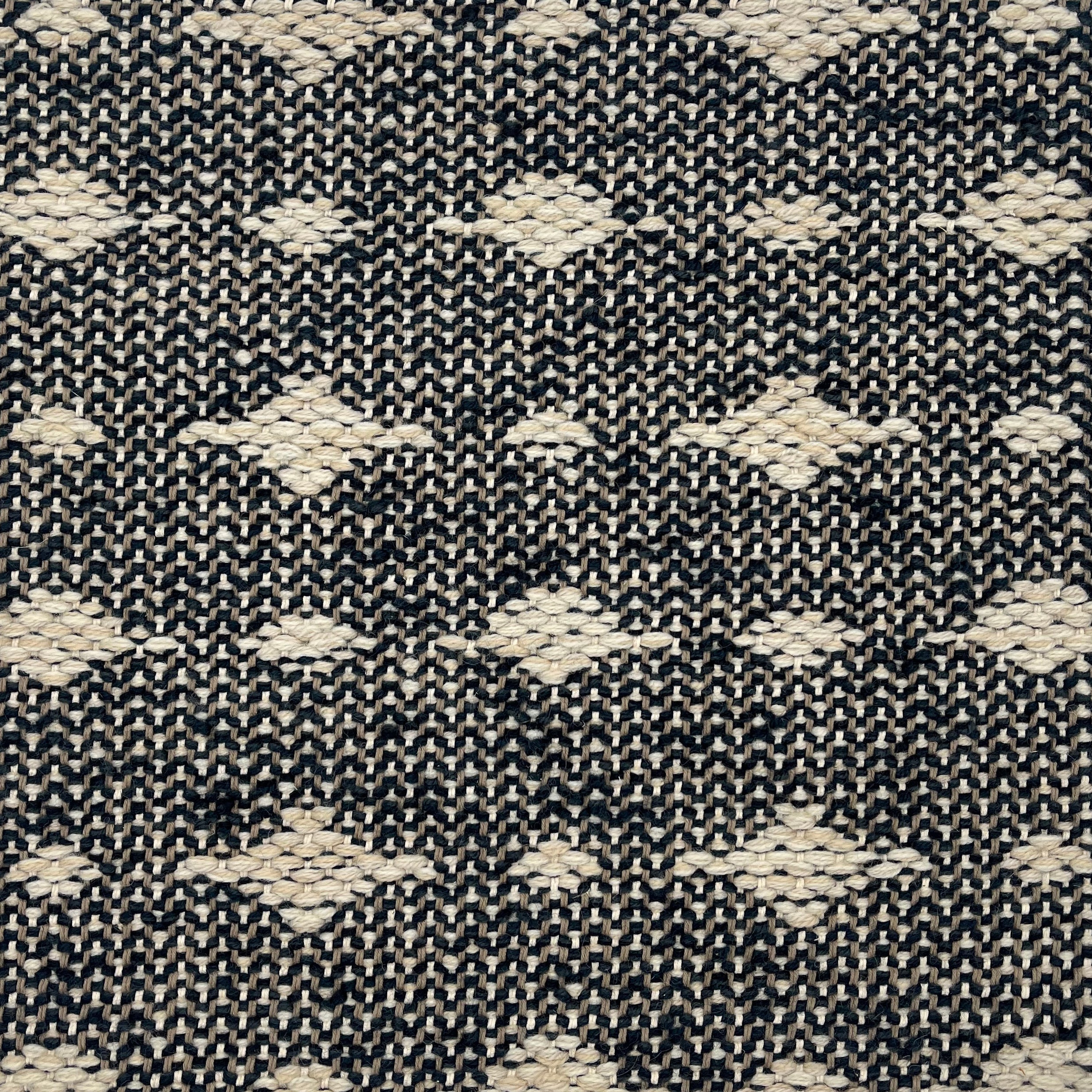 Handwoven rug detail in a contemporary spotted design in black and white