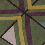Close-up of a geometric patterned rug with green, purple, and yellow colors.