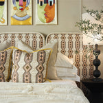 Decorative bedroom with patterned headboard, pillows, and wall art.
