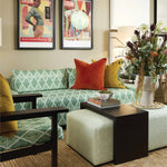 Living room with a green patterned sofa, colorful pillows, and decorative items.